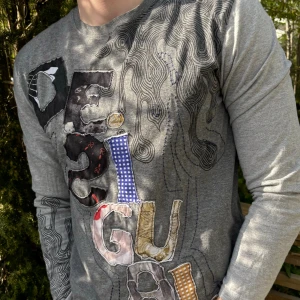 Desigual tröja - Desigual tröja med coola mönster och bokstäver i olika tyger, vilket ger en kreativ look. (strl XL, men passar för den med strl L)