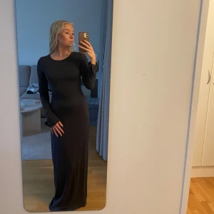  långärmad maxiklänning  - Soft touch klänning från Gina i storlek s i en marinblå/gråblå färg. Klänningen har en tight passform som framhäver figuren och är gjord i ett mjukt, stretchigt material. Enkel och stilren design som känns modern och clean.