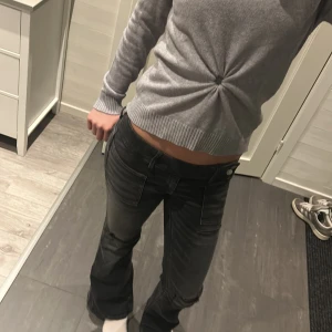Svarta bootcut jeans Gina Tricot 158 - Snygga svarta jeans från Gina Tricot i storlek 158. Modellen har bootcut-ben, låg midja och coola detaljer med dubbla knappar framtill. Jeansen har stora fickor både fram och bak och är tillverkade i klassiskt jeansmaterial.