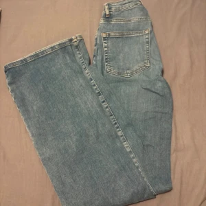 Blå Curve Bootcut Jeans 30/30 - Bootcut jeans från Curve i ljusblå tvätt med klassiska fem fickor och orangea sömmar. Jeansen har normal passform och är tillverkade i mjukt denimtyg som sitter skönt hela dagen. Perfekt för dig som gillar en avslappnad och snygg stil.