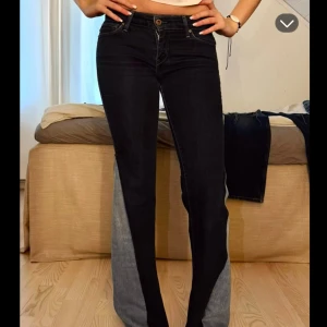 Levi's jeans - Snygga svarta Levi's jeans med bootcut passform och coola grå kontrastpaneler längs insidan av benen. Klassisk femficksmodell med knapp och dragkedja framtill. Jeansen har en markerad midja och är tillverkade i stretchig denim för skön passform.