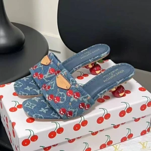 Louis Vuitton sandaler med körsbärshäl - Unika Louis Vuitton sandaler i blå denim med broderade röda körsbär och vita detaljer. Skorna har öppen tå, platt sula framtill och en cool klack formad som ett körsbär. Guldiga metalldetaljer framtill och exklusiv känsla. Perfekta för dig som vill sticka ut i sommar.