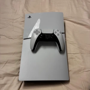 PlayStation 5 - Sony PlayStation 5 i mycket fint skick, komplett med original DualSense-kontroll, HDMI-kabel och strömkabel. Konsolen och tillbehören ser ut att vara välvårdade utan synliga repor eller skador. Perfekt för dig som vill ha en kraftfull spelupplevelse direkt ur kartongen.