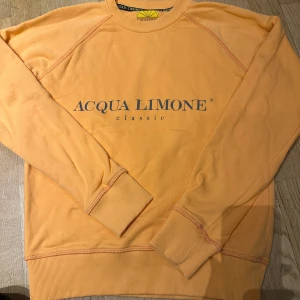 Acqua Limone orange sweatshirt S - Säljer en snygg orange sweatshirt från Acqua Limone i storlek S. Tröjan har klassisk logga framtill och en stor citronskiva på ryggen. Mjuk bomullskvalitet och ribbade muddar vid ärmslut och nederkant. Perfekt för dig som gillar färg och vill sticka ut.