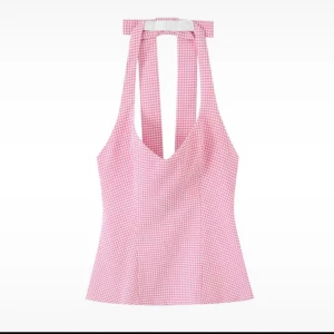 Rutig rosa linnetopp från Zara - Superfin rosa linnetopp från Zara med vitt rutmönster och breda axelband som knyts i nacken. Toppen har en v-ringad hals och är figurnära med lätt utsvängd nederkant. Materialet är mjukt och har en vit insida. Perfekt för sommarens alla tillfällen!