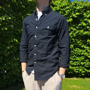 Svart Ralph Lauren skjorta - Stl S, Slim fit - Hej säljer en snygg Ralph Lauren skjorta I färgen svart. Perfekt till sommaren! 🏝🏖 Skick: 9/10 utan defekter. Stl: S, Slim fit. Han på bilden är 170cm. 🤗