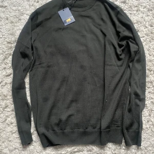 Svart stickad tröja från Cavalli Class - Svart stickad tröja från Cavalli Class med rund hals och långa ärmar. Stilren och enkel design som passar perfekt till jeans eller chinos. Mjukt material och ribbade muddar vid ärmslut och nederkant. Nylris ca 2000