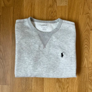 Grå sweatshirt från Polo Ralph Lauren - Säljer en stilren grå sweatshirt från Polo Ralph Lauren i storlek XS. Tröjan har rund halsringning, långa ärmar och klassisk broderad logga på bröstet. Tillverkad i mjuk bomullsmix för en skön känsla. Perfekt för en clean och avslappnad look.