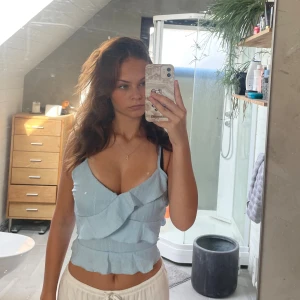 Ljusblå volang topp  - Supersöt ljusblå linnetopp med volangdetaljer och smala justerbara axelband. Finns drag kedja längt med ena sidan. 💕💕