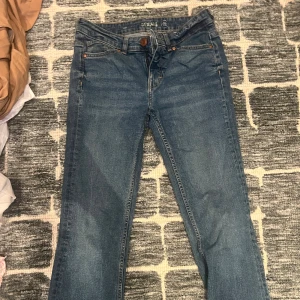 Blå bootcut jeans med klassisk look - Snygga blå jeans med bootcut passform och klassisk femficksdesign. Jeansen har normal midja och är tillverkade i ett mjukt denimtyg som ger en skön känsla. Perfekta för dig som gillar en tidlös stil med lite utsvängda ben.