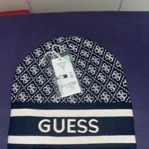 GUESS MÖSSA  - Guesss mössa helt ny passar vem som helst. Har haft den några gånger men annars är den helt perfekt. Priset kan diskuteras 