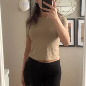 Beige croppad t-shirt i skims/tränings material  - (Välj 3 plagg för 70kr - gäller alla plagg som kostar mellan 20-40kr) Säljer en enkel och stilren beige croppad t-shirt med korta ärmar. Material är jätte skönt och lätt, skulle beskriva som likt skims eller tränings material. 