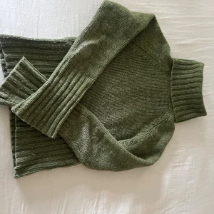 Olivgrön stickad polotröja Eye of Eden - Säljer en olivgrön stickad polotröja från Eye of Eden i storlek XS. Tröjan har bred ribbad mudd i midjan och vid ärmslut, har lång ärm och hög polokrage. Perfekt för dig som gillar en chill och snygg stil.