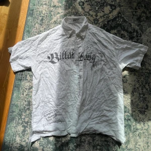 Vit kortärmad skjorta Billabong XXL - Säljer en vit kortärmad skjorta från Billabong i storlek XXL. Skjortan har svart tryck med Billabong-logga både fram och bak, klassisk krage och knappar hela vägen. Materialet är lätt och bomulligt, perfekt för chill dagar. Snyggt rutmönster i tyget för extra detalj.