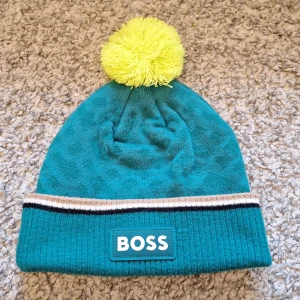 BOSS Aston Martin F1 Team mössa - Grön BOSS Aston Martin F1 Team mössa med en boll på toppen. Använda fåtal gånger och är i jättebra skick. Har inga defekter eller så. Skick: 9.5/10