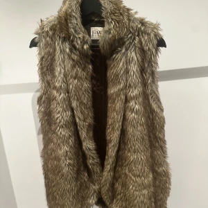 Brun pälsväst från FAV - Pälsväst från FAV med öppen front utan knappar. Passar S/M