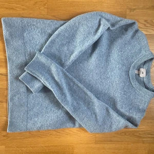 Ljusblå stickad tröja från H&M - Ljusblå stickad tröja från H&M i regular fit. Tröjan har rund halsringning och långa ärmar med ribbade muddar. Perfekt för dig som gillar enkel och stilren design med soft vibe. Materialet känns mjukt och passar bra när det är lite kyligt ute.