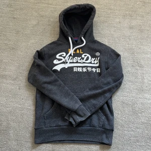 Superdry Hoodie  - Tja! Säljer nu denna feta Superdry hoodie! Den är fodrad så perfekt till dessa lite svalare dagar nu i höst och vinter!❄️Nypris: 1499 kr❌‼️Vårt pris: 499 kr✅Ställ en fråga vid minsta fundering och pris kan diskuteras!🤝