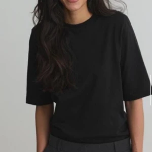 Svart basic t-shirt i bomull - Enkel svart t-shirt med rund hals och korta ärmar. Modellen är rak och något loose i passformen, perfekt för en clean och stilren look. Tillverkad i mjuk bomull som känns skön mot huden. Missade retur dagarna då jag va på semester. Den är helt oanvänd och med pristaggen kvar.