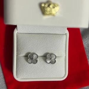 Silverfärgade blomformade örhängen - Snygga örhängen i silverfärg med fyrklöverformad design och räfflade detaljer. Kanterna är dekorerade med små pärlliknande kulor och mitten har en liten rund detalj. Perfekta för dig som gillar stilrena och unika smycken. Rostfritt 