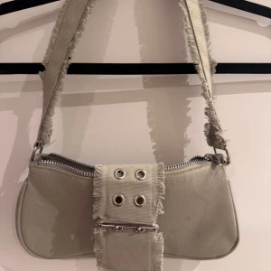 Grön väska!! - Fin axelremsväska i en fin ljusgrön färg. Väldigt cool med ”bältes” detaljen och fransarna. Aldrig använd💗