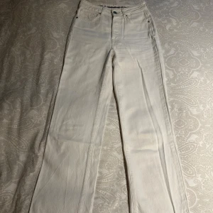 Vita raka jeans Never Denim - vita/creme Never Denim jeans med hög midja, raka ben och klassisk femficksdesign.