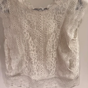 Vit spetsblus med v-ringning - Säljer denna vita spetsblusen i strl S. Väldigt fin i ryggen då de är enbart spets. Säljer då den ej kommer till användning💗