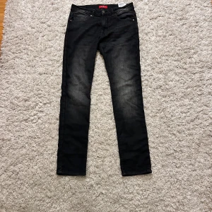 Svarta jeans från Guess, storlek 33 - Snygga svarta jeans från Guess i storlek 33. Jeansen har en jävligt snygg tvätt på knänen, det är jäckligt najs då de är här en väldigt mjuka känsla på de 