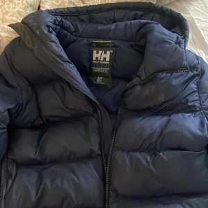 Mörkblå pufferjacka från Helly Hansen - Säljer en mörkblå pufferjacka från Helly Hansen. Jackan har en oversized/midfit passform och är vadderad för extra värme. Perfekt för kalla dagar och har en clean look med diskret HH-logga på bröstet och hela loggan på nedre ryggen. Jackan köptes förra vintern och har inga som helst hål eller defekter. Precis som ny! ❣️Nypris 4500kr (swipa för fler bilder och även bilder på!) 