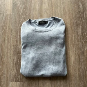 Ljusblå tröja från Dressmann S - Superskön ljusblå tröja från Dressmann i mjuk Supima-bomull | färgen ser ut att vara grå på bilden men den är väldigt ljus blå | Uppskattas till 170 cm till 180 cm | skriv för mer info!!