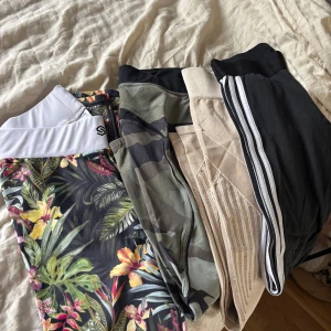 Paket av olika träningsbyxor!  - Fyra par träningsbyxor: Stronger, komoflauge- better bodies- låg midja, och liten dragkedja vid ankeln, Adidas i bomull, och ett par beige andningsbara som skall förbättra cirkulationen och förebygga celluliter, så ej sönder, modellen ser ut så, sitter riktigt snyggt bak 👌🏻och hålle in magen. Perfekta för dig som vill ha variation i garderoben. St S/M. Jag har S och alla sitter perfekt på mig. Pris för alla 4 
