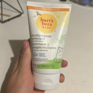 Burt's Bees Baby multipurpose ointment - Multipurpose ointment från Burt's Bees Baby med sheasmör. Tuben är vit med orange och gröna detaljer samt en söt björnillustration. Produkten är naturlig, parfymfri och passar för känslig hud. Innehåller 113,3 g salva.