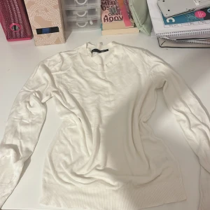Vit stickad tröja från 157 - Säljer en vit stickad tröja från 157 i storlek S. Tröjan har rund hals, ribbade muddar vid hals, ärmslut och nederkant samt långärmad passform. Perfekt för lager-på-lager och chill stil under höst och vinter.