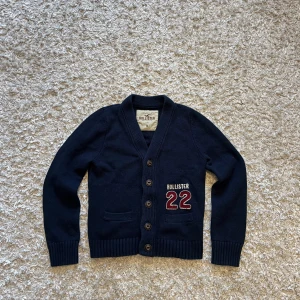 Marinblå cardigan från hollister - Riktigt snygg blå kofta från hollister. Den är använd men i gott skick utan några fläckar eller hål. Står storlek M men jag tycker den sitter som en S. Tveka inte på o skriva vi fler frågor!