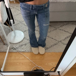 Blå bootcut jeans med slitningar - Jättefina jeans från gina i storlek M! 