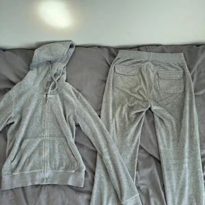 Grå Juicy Couture set i velour - Grått Juicy Couture-set – tröja M, byxor S (superfint skick!)  Säljer mitt gråa Juicy Couture-set i sammet/velour. Tröjan är i storlek M, byxorna i S – passar dig som brukar ha S–M. Fint använt skick, inga fläckar eller noppor. Väldigt bekvämt och sitter supersnyggt!  Pris: 900 för båda  Göteborg → Kan hämtas i Göteborg eller skickas mot frakt.