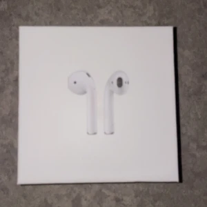 Apple AirPods med trådlöst laddningsetui - Säljer ett par Apple AirPods med trådlöst laddningsetui. Produkten är i originalförpackning och ser helt ny ut, utan synliga tecken på användning. Perfekt för trådlös musik och samtal med smidig laddning. Komplett med allt som medföljer vid nyköp.