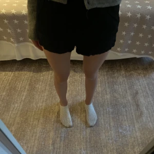 Svarta shorts från Kappahl  - Svarta shorts från KappAhl med knytband i midjan. De har en lös passform och är tillverkade i ett mjukt och lätt bomullstyg, perfekta för varma dagar. Använda en gång så väldigt bra skick! Står att de är stl 146, men de passar mig som har XS-S i vanliga fall. Hör gärna av er om frågor!❤️