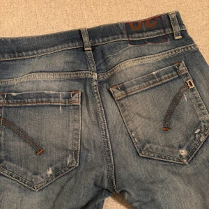  jeans från Dondup - Säljer ett par blå jeans från Dondup med snygga slitningar