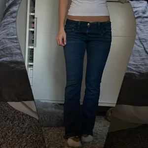 Mörkblå lowwaist bootcut jeans - Säljer ett par mörkblå lowwaist bootcut jeans från Gina Tricot i storlek 164. Jeansen är supersnygga speciellt de tjocka sömmarna på fickorna, de är också jättesköna! Nyligen köpta och sällan använda.