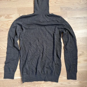 Stickad polo tröja   - Stickad tröja i merino wool blend. Tröjan är i superbra skick och säljs då den inte kommer till användning. I en fin grå färg och superskönt material.