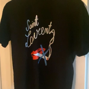 Svart Saint Laurent t-shirt  - Säljer min svarta t-shirt från Saint Laurent                        Inga som helst deffekter och i väldigt bra skick.               Säljer den till väldigt bra pris då jag behöver lite pengar och de börjar närma sig vintern.                             Pris ej hugget i sten!                                                                 Hör gärna av dig