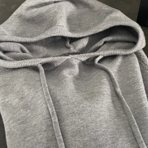 Grå Kashmirhoodie med snörning  - Mysig grå kahsmir hoodie med huva och snörning.  Storlek xxs. Tröjan har lång ärm och ribbade muddar vid ärmslut och nederkant. Perfekt för kyliga dagar när du vill vara både bekväm och stilren.