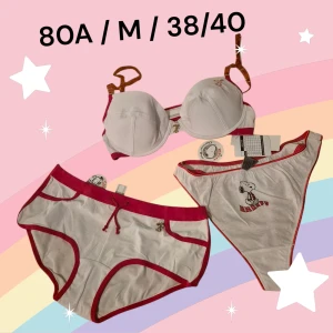 Underklädesset med Snobben-bh, hipster och string - Supergulligt underklädesset. Först en bh med Snoopy eller Snobben på. Den är vit med röda detaljer. BH:n har uttagbara kuddar i kuporna och orange'a halvgenomskinliga axelband som går att ta av. Det ingår också två par trosor - ett par hipsters och ett par stringtrosor. Allt är nytt med orginaletiketten kvar. Kommer från konkurslager. Finns många storlekar, fråga om du inte hittar. Rabatt om du köper flera. Storlekar: BH 80A, Hipster M, String 38/40. 