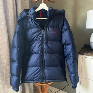Polo ralph lauren jacka - Nu säljer vi denna navy/mörkblå Polo Ralph Lauren puffer jacket. Storlek S men passar även M bra! Skicket är super bra och inga defekter finns! Nypris är ca 5000 kr! Pris kan diskuteras!                                                       Mvh Garçon Studios