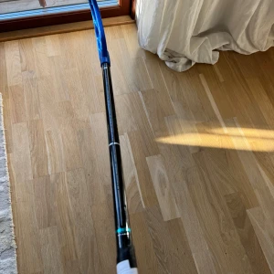 Unihoc Pro 26 Floorball Stick 94 cm  bladet är väldigt slitet men klubban är helt ny - Unihoc Pro 26 innebandyklubba i svart med blått blad och vit lindning. Klubbans skick är mycket bra, med minimalt slitage på blad och grepp. Perfekt för både träning och match. Stabil och lätt konstruktion för optimal bollkontroll.