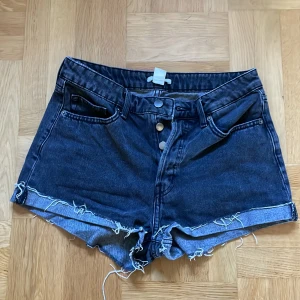 Mörkgråa jeans shorts  - Säljer ett par mörkgråa shorts som är midwaist i storlek 38, använt sällan och är i godskick 
