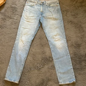 Levi's 511 ljusblå jeans W32 L30 - Ljusblå Levi's 511 jeans med klassisk femficksdesign och läderpatch bak i midjan. Jeansen har en slim passform och raka ben, tillverkade i mjukt denimtyg. Perfekta för dig som gillar en avslappnad men ändå stilren look.