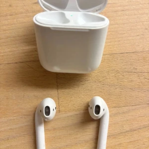 AirPods 2 - Säljer ett par Apple AirPods 2 med laddningsetui. Hörlurarna är trådlösa och fungerar utmärkt med både iPhone och andra enheter. Skicket är bra med mindre tecken på normalt bruk, inga synliga större repor eller skador. Perfekt för musik, samtal och träning.