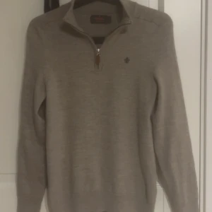 Beige merinoullströja Morris half zip - Snygg beige tröja från Morris i 100% merinoull. Klassisk modell med half zip och liten broderad logga på bröstet. Långärmad och perfekt för lager-på-lager under höst och vinter. Skön och stilren, passar till allt. Är en medium men har krympt i tvätten till en xs skulle jag säga